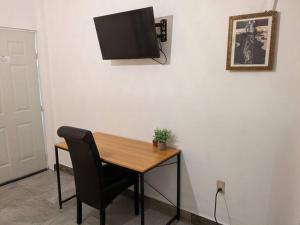 mesa con silla y TV en la pared en Estudio Bengala, en San José del Cabo
