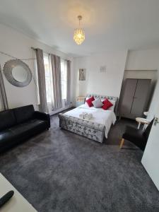 a large bedroom with a bed and a couch at Three bedroom House in London