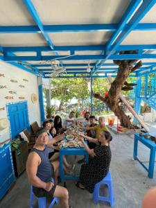Eine Gruppe von Menschen, die an einem Tisch sitzen und Essen essen. in der Unterkunft Má Năm Homestay in Phương Phi