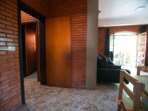 uma sala de estar com uma parede de tijolos e uma porta de madeira em Residencial Colling em Canela