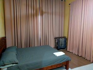 a bedroom with a bed with pink drapes at Homestay Sri Uda A in Alor Setar
