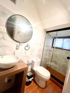 La salle de bains est pourvue de toilettes, d'un lavabo et d'un miroir. dans l'établissement Hostal María Angola, à Cusco