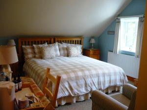 une chambre avec un lit et une table avec une chaise dans l'établissement White Cottage Bed and Breakfast, à Seisdon