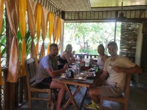 a group of people sitting at a table at Balili Farm At Nacpan in El Nido