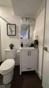 een badkamer met een wit toilet en een wastafel bij Oakville's Retreat in Oakville