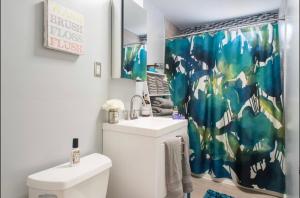 a bathroom with a sink and a toilet and a shower curtain at Comfort Stay in Boston