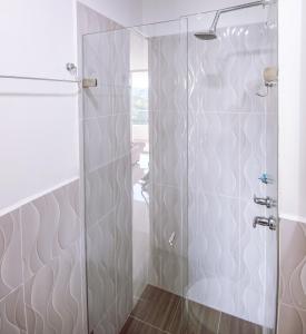 a shower with a glass door in a bathroom at Apto Di Sole Santa FeAntioquia in Santa Fe de Antioquia