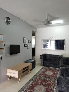 ein Wohnzimmer mit einem Sofa und einem Couchtisch in der Unterkunft RizqFateh Homestay in Keluang