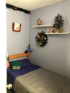a bedroom with a bed and christmas trees on shelves at Don Quijote Family Homestay in Santiago
