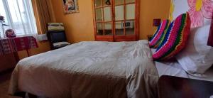 a bedroom with a bed with pillows on it at Reinbo Garden in Cusco