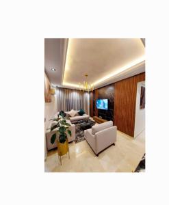 a living room with two couches and a tv at modern apartment opposite the Hassan2 mosque, very well equipped and stylish, 85 m² with gym and direct sea view with underground garage. (couple of Arab origin without marriage certificate will be refused) in Casablanca