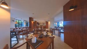 une salle à manger avec des tables et des chaises dans un restaurant dans l'établissement EKHO Surf, à Bentota