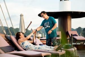 a man giving a woman a high five on a boat at Mila Lux Cruises in Ha Long