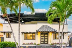 een huis met palmbomen ervoor bij New! Miami & Calle Ocho Simpson's Funhouse! in Miami
