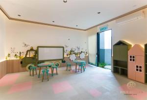 a classroom with two tables and chairs and a chalkboard at Scarletz Signature Suites, KLCC in Kuala Lumpur