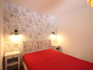 - une chambre avec un lit rouge et 2 tables de chevet dans l'établissement Appartement Mont-Dore, 2 pièces, 6 personnes - FR-1-415-150, à Le Mont-Dore