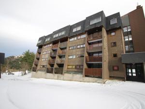 un immeuble avec de la neige devant lui dans l'établissement Appartement Mont-Dore, 2 pièces, 6 personnes - FR-1-415-150, à Le Mont-Dore