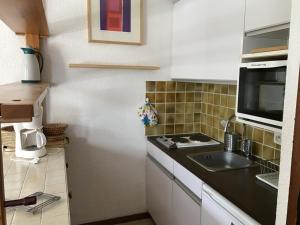 a small kitchen with a sink and a microwave at Studio Les Orres, 1 pièce, 4 personnes - FR-1-322-578 in Les Orres