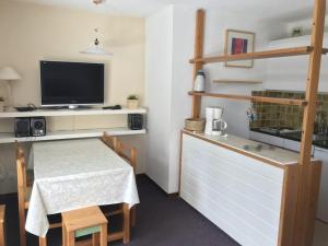 una cocina con mesa y TV y una cocina con mesa en Studio Les Orres, 1 pièce, 4 personnes - FR-1-322-578 en Les Orres