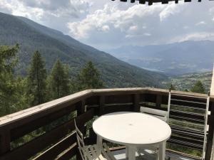 una mesa blanca y sillas en un balcón con montañas en Studio Les Orres, 1 pièce, 4 personnes - FR-1-322-578 en Les Orres