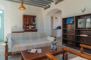uma sala de estar com um sofá e uma televisão em Eco-Luxe Retreat in Ano Petali, Sifnos em Apollonia