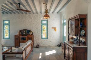 een woonkamer met een bank en een plafondventilator bij Eco-Luxe Retreat in Ano Petali, Sifnos in Apollonia