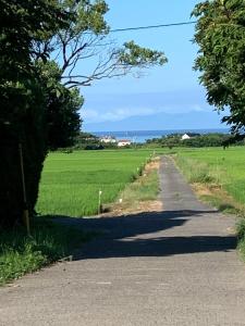 un camino que conduce a un campo con el océano en Ao to Yuuhi - Vacation STAY 34462v, en Tateyama
