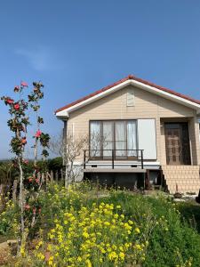 uma casa com um campo de flores em frente em Ao to Yuuhi - Vacation STAY 34462v em Tateyama