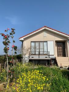 een huis met een bloemenveld ervoor bij Ao to Yuuhi - Vacation STAY 34462v in Tateyama