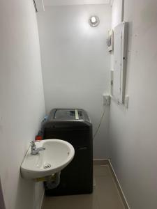 baño con lavabo y cubo de basura en Apartahotel APR en Cali