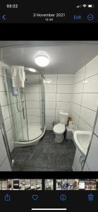 a bathroom with a shower and a toilet and a sink at St James Apartments in Leeds