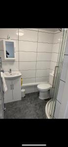 a white bathroom with a toilet and a sink at St James Apartments in Leeds