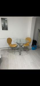 two chairs and a glass table in a room at St James Apartments in Leeds