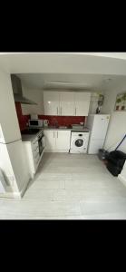 a small kitchen with white cabinets and a stove at St James Apartments in Leeds