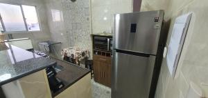 a kitchen with a stainless steel refrigerator and a microwave at Condomínio Itaparica III in Guarujá