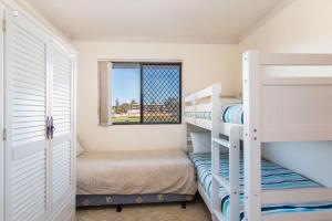 a bedroom with two bunk beds and a window at Seabreeze 3 in Tuncurry