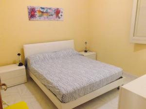 1 dormitorio con 1 cama y una pintura en la pared en Appartamento La Dimora Siciliana, en Trapani