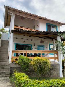 une maison avec une terrasse couverte et des escaliers en face de celle-ci dans l'établissement Cabaña Cangrejito Olon, à Olón
