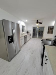 eine Küche mit einem Kühlschrank aus Edelstahl und weißen Schränken in der Unterkunft Mustang House in Sioux City