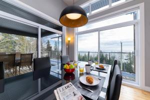 comedor con mesa y ventana grande en Les havres du Massif AUB 148, en Petite-Rivière-Saint-François