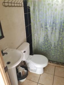 a bathroom with a white toilet and a sink at Casa Jaragua in Barra de Santiago