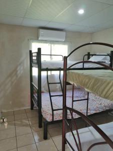 2 Etagenbetten in einem Zimmer mit Fenster in der Unterkunft Casa Jaragua in Barra de Santiago