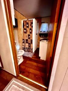 a hallway leading to a bathroom with a toilet at O Me, O Mio Cabin near the AuSable River in Mio