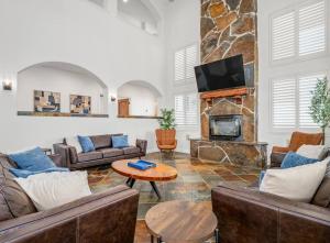 a living room with couches and a stone fireplace at Luxury 4 Acre Estate - Pickleball, Pool, Hot Tub! in Lockeford