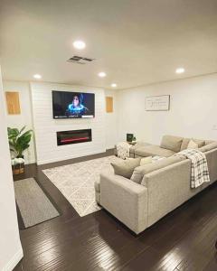 a living room with a couch and a flat screen tv at CasAHermosa Cozy getaway ! in Las Vegas