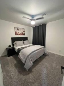 a bedroom with a bed with a ceiling fan at CasAHermosa Cozy getaway ! in Las Vegas