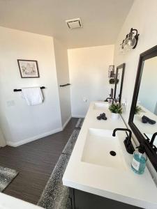 a white bathroom with a sink and a mirror at CasAHermosa Cozy getaway ! in Las Vegas