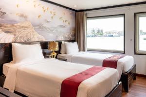 a hotel room with two beds and a window at Dragon Crown Legend Cruise in Ha Long