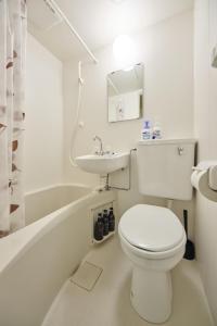 a white bathroom with a toilet and a sink at TORA HOTEL Tokyo Ueno 寅ホテル 上野 B in Tokyo +35 photos