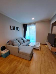 uma sala de estar com um sofá e uma televisão em My Resort Condo Hua Hin By Hua Hin Hip em Hua Hin
